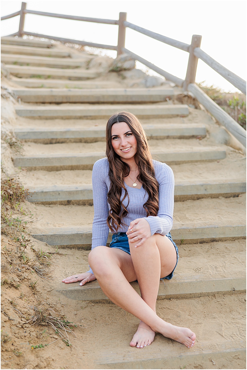 Torrey Pines State Beach Senior Photo Session | High School Senior Girl posing on wooden stairs at beach 
