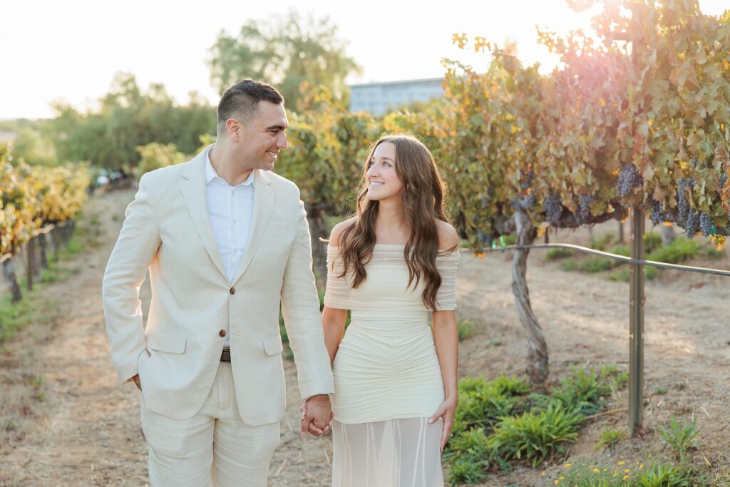 southern california wedding welcome party dinner Wilson Creek winery couple in engagement attire walking hand in hand before dinner party