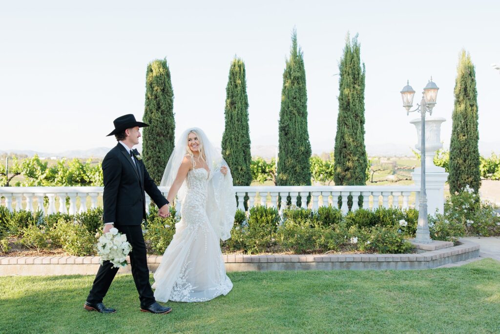 Southern California winery wedding photographer  bride and groom walking through ceremony site